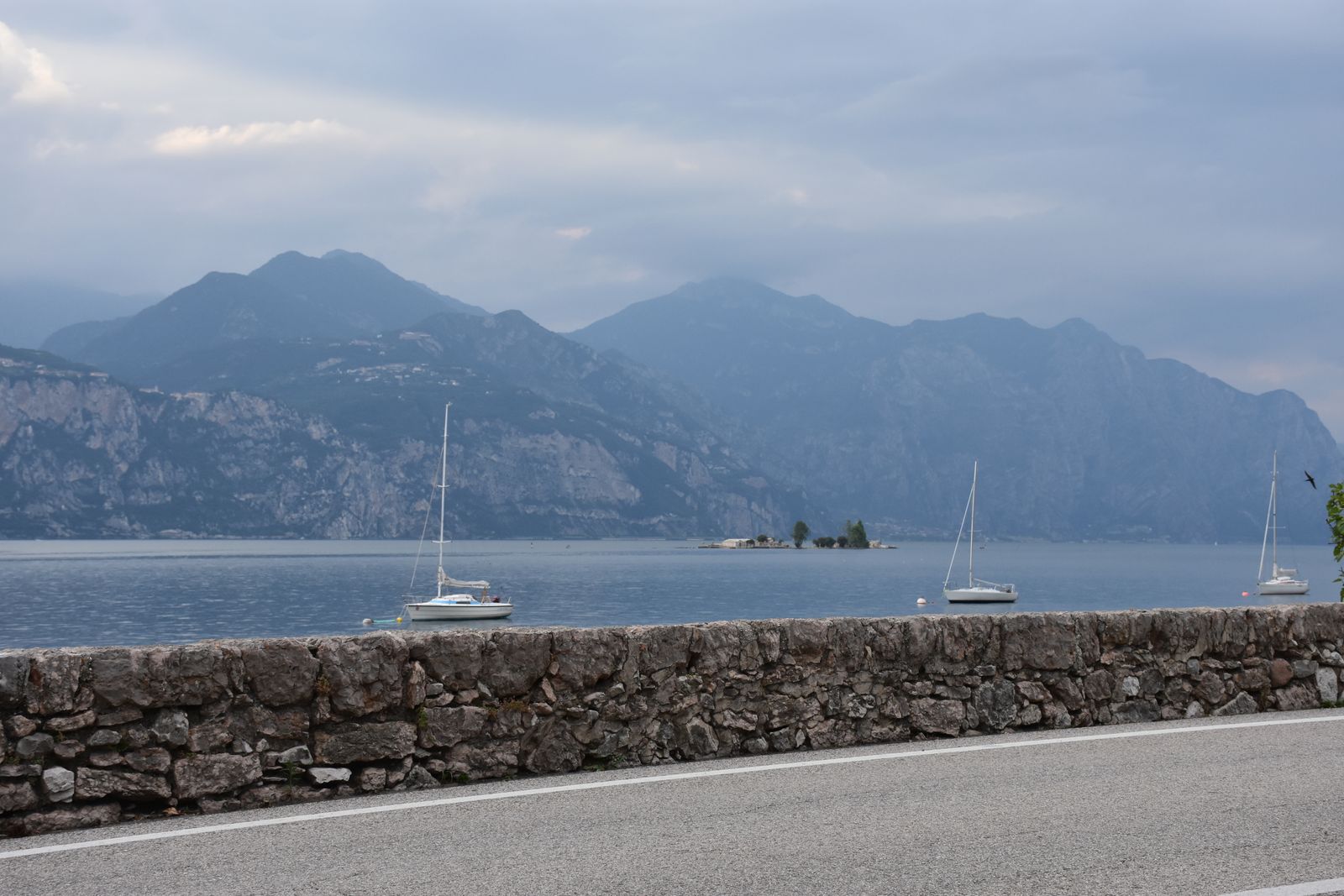 Sailing boats on Lake Garda beneath the mountains