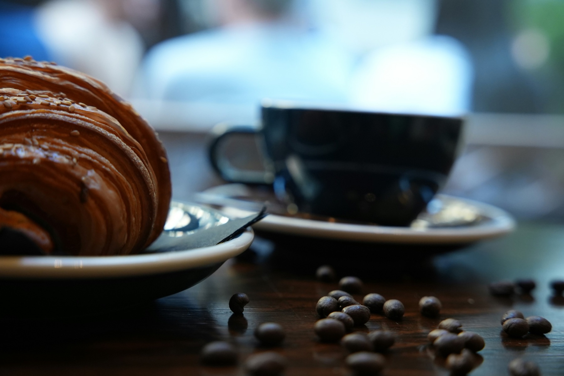 A croissant and coffee on a cafe table