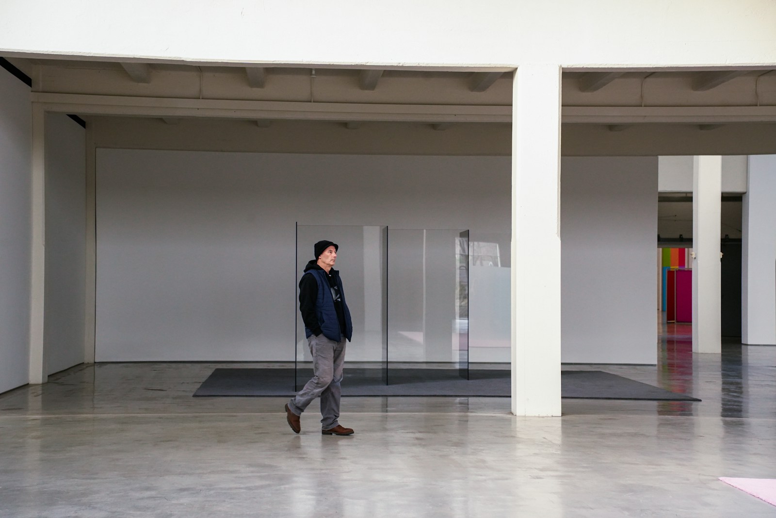 A visitor walking through a minimalist contemporary art gallery