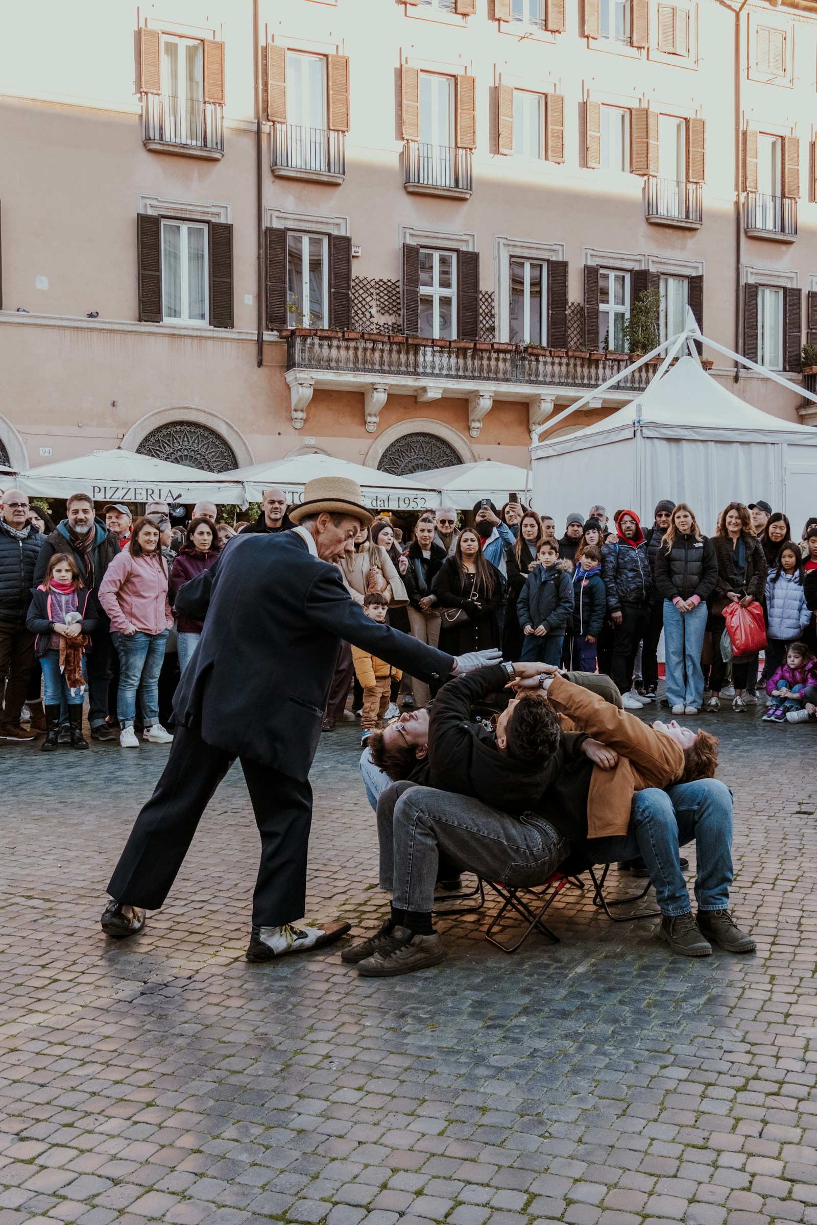 A street performer entertaining an audience in an Italian square