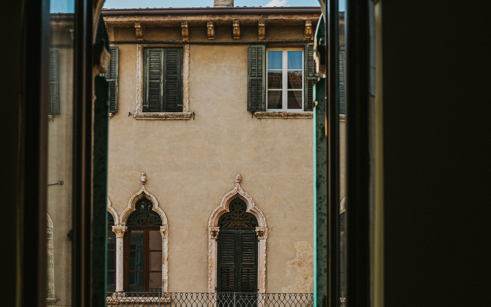 A view through an arched window onto a historic Verona facade